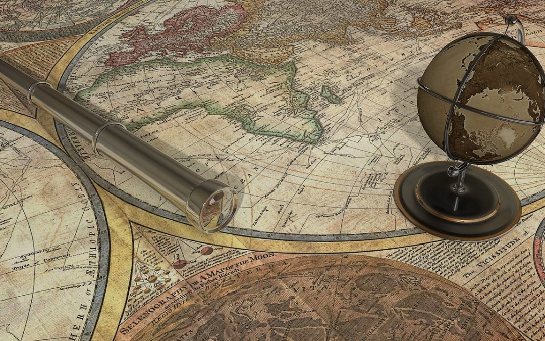 Eine historische Weltkarte, darauf ein Fernrohr und ein Globus